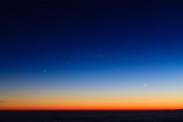 Obraz premium Mountain silhouette over clouds,sky at twilight with moon