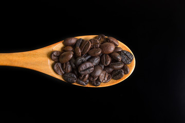 Roasted coffee beans on wood spoon