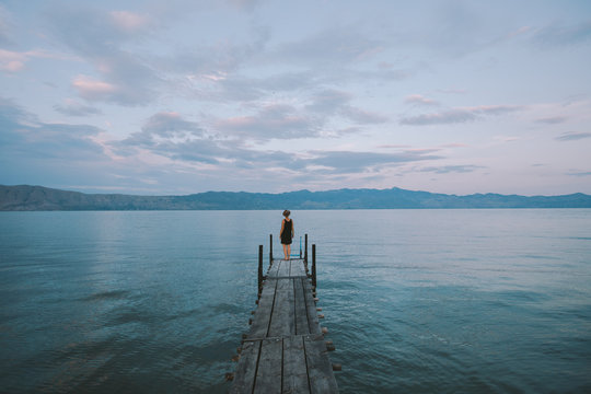 Woman standing on a pier by the lake
