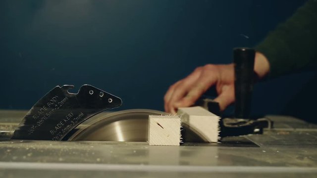 Close up on a man using a table saw