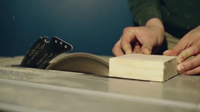 Close up on a man using a table saw