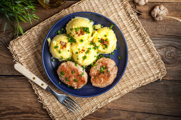 Meatballs served with boiled potatoes on a plate.