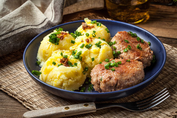 Meatballs served with boiled potatoes on a plate.