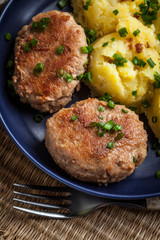 Meatballs served with boiled potatoes on a plate.