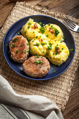 Meatballs served with boiled potatoes on a plate.