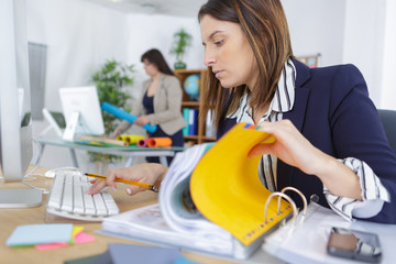 young businesswoman looking through a stack of file folders