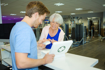 man in gym giving plaster to lady with cut finger