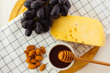 Cheese, almond and honey on wooden plate