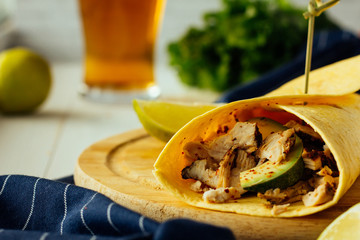 Wrap with chicken and avocado on wooden plate