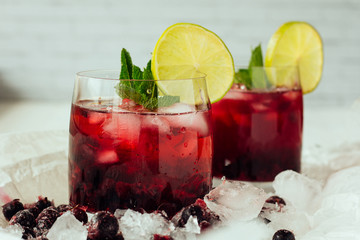 Berry cocktails with mint and lime in glasses