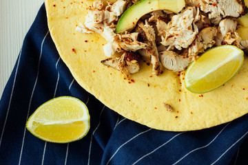 Tortilla with chicken, avocado and lime top view