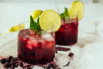Berry cocktails with mint and lime in glasses
