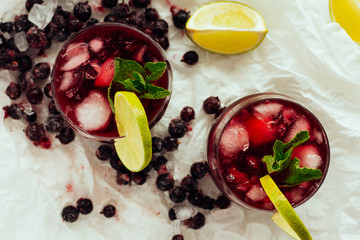 Berry cocktails with mint and lime in glasses top view