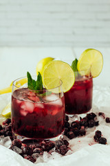 Berry cocktails with mint and lime in glasses top view