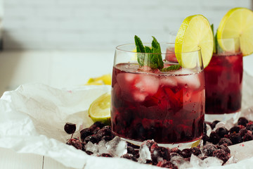 Berry cocktails with mint and lime in glasses top view