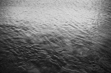 Obraz premium Rain drops ripples in the sea. Black and white background pattern texture.