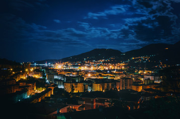 Night panoramic overview of La Spezia city, Italy. Picturesque scene with illuminated colorful buildings in moonlight.