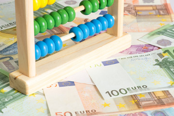 Ein traditioneller Abakus und viele Euro Geldscheine