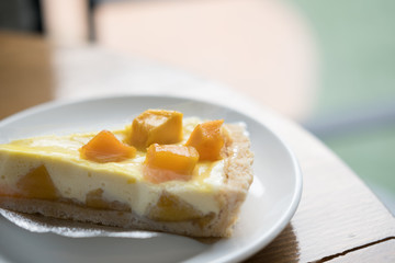 A piece of cheese cake tart with fresh mango, delicious mango tart