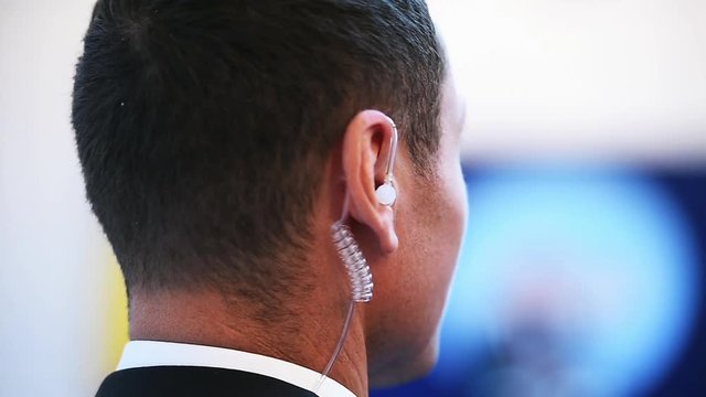 Detail with a bodyguard wearing in ear headset