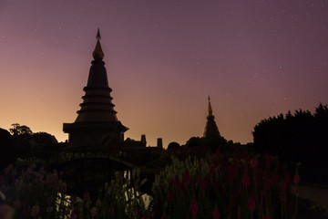 Night sky with lot of shiny stars and two pagoda in Doi Inthanon mountain, natural astronomy landscape