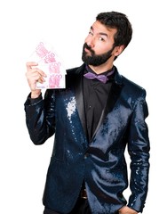 Handsome man with sequin jacket taking a lot of money