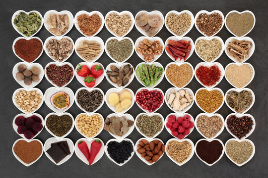 Aphrodisiac food sampler of foods to promote sexual health in heart shaped china bowls on slate background.

