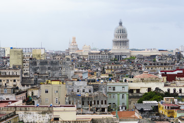 Fototapeta na wymiar View of the cityscape at summer sunny day. The reconstructed Capitol and architecture of old, ancient ragged houses and skyscrappers of Havana