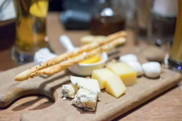 Set of various cheese on plate, with blur background