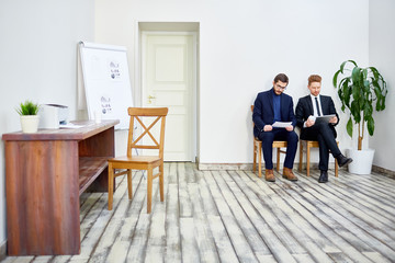 Two specialists reading data or preparing their reports for seminar