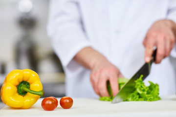 Gresh yellow pepper and ripe tomatoes on workplace of chef