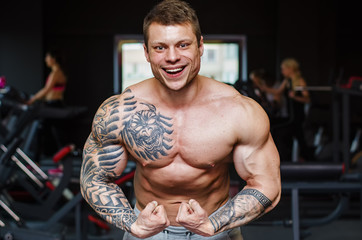 Strong bodybuilder with six pack, perfect abs, shoulders, biceps, triceps and chest