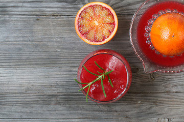Red orange juice. Grey wooden background. Top view.