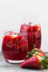 Strawberry drink. Grey white wooden background. Close up photo.