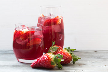 Strawberry drink. Grey white wooden background. Close up photo.