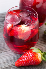 Strawberry drink. Grey white wooden background. Close up photo.