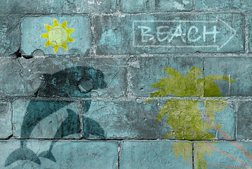 Indicazioni per raggiungere la spiaggia. Scritte e simboli informativi per il visitatore o il turista. Sono disegnati dei delfini, una palma e un sole stilizzato.