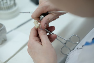 Artificial teeth, prosthetics, hands while working on the denture