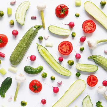 Fresh vegetables in a cut on a white background. Pattern from vegetables. Food background.  Cucumbers, tomatoes and zucchini in a cut.