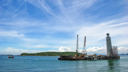 Supply Vessel Alongside Offshore Jack Up Drilling Rig Over The Production Platform in The Middle of The Sea