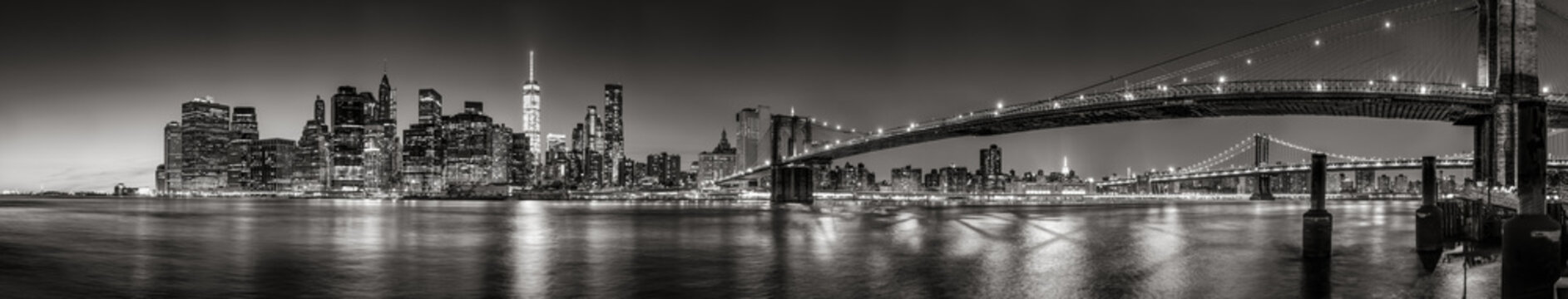 Fototapeta Panoramiczny czarno-biały widok drapaczy chmur na dolnym Manhattanie o zmierzchu z Brooklyn Bridge i East River. Nowy Jork