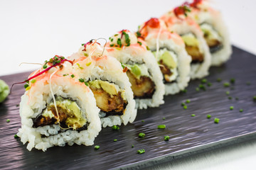 Japanese traditional rolls and sushi on a black stone plate