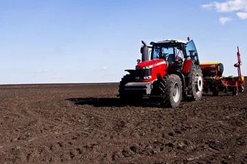 Zelfklevend Fotobehang Tractor in a large spacious field © Pavlo