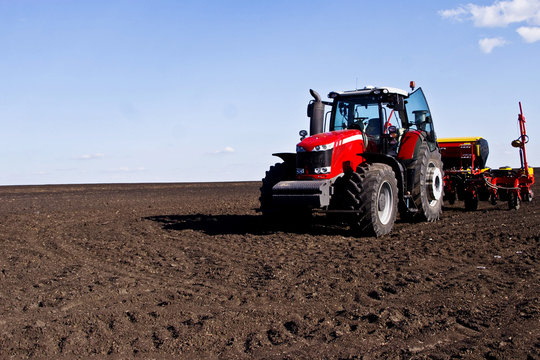 Fototapeta Tractor in a large spacious field