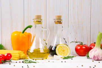 Spaghetti, tomatoes cherry, olive oil, herb and spices on old white wooden background. Set for healthy foods. Ingredients for salad.