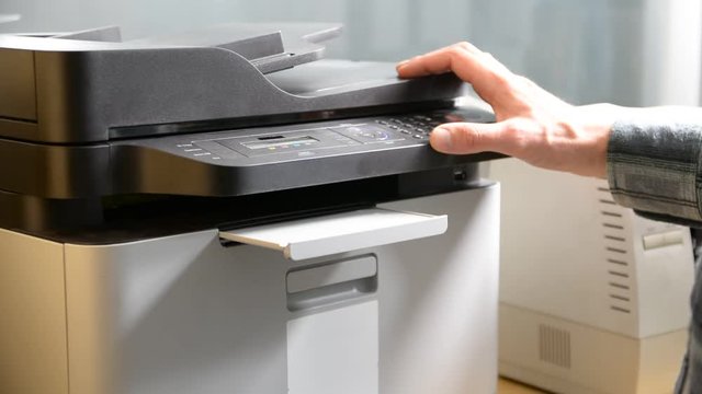Male hand printing document on printer or fax or scanner, then retrieving paper sheet