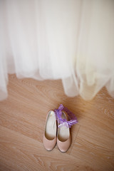 Bride's shoes under a wedding dress