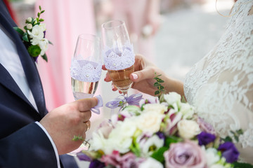 The bride and groom hold wedding champagne in their hands