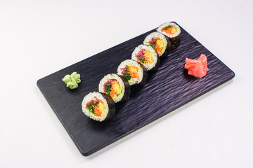 Vegetarian rolls and sushi on a black stone plate. Top view