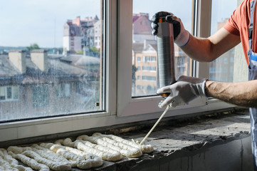 Worker is using a polyurethane foam. - obrazy, fototapety, plakaty